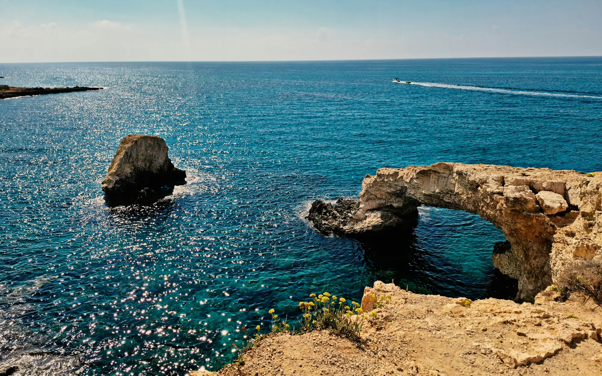 Natural sea arch on the Cyprus coast above clear blue water
