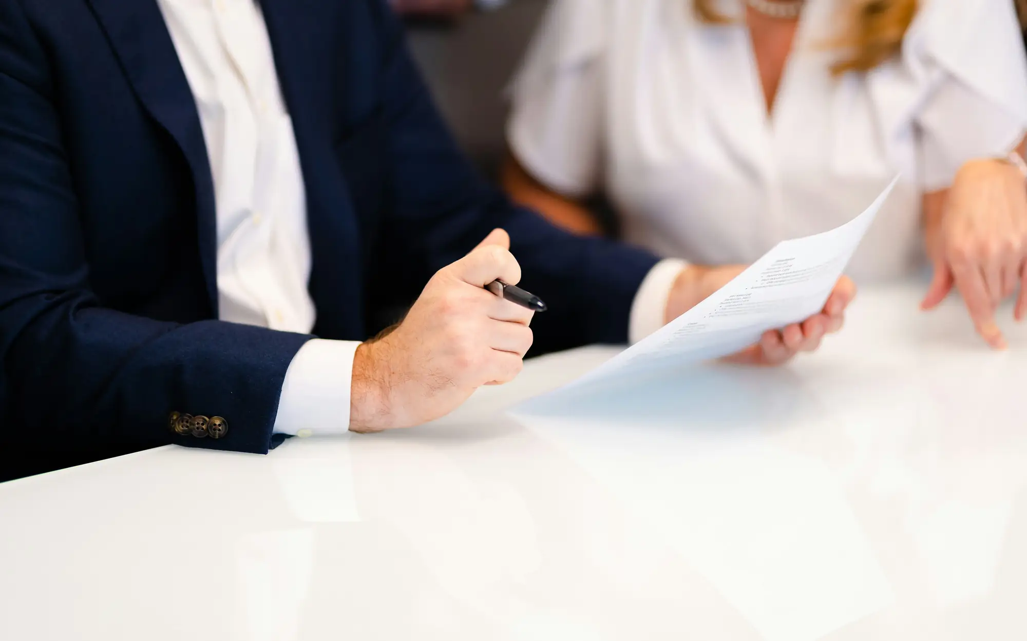 Two people reviewing and signing an application document