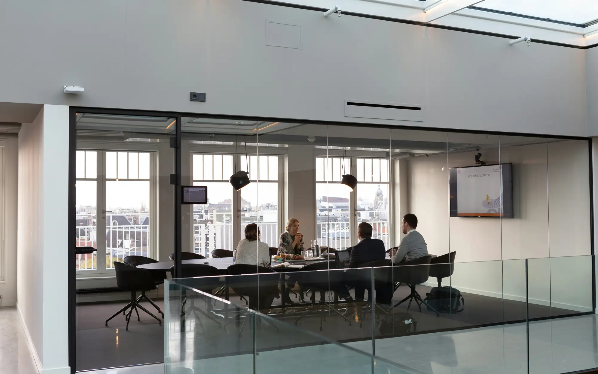 Glass-walled boardroom with a team meeting around a table