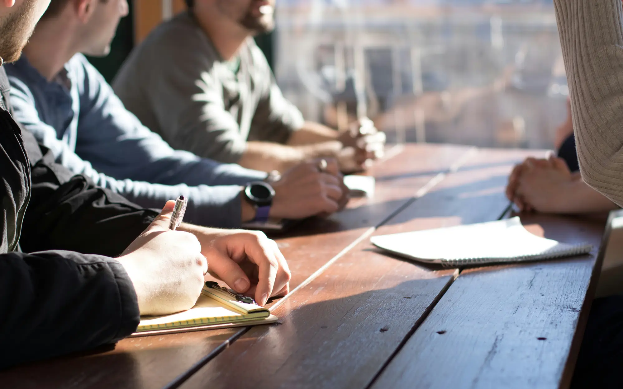 Advisors working together at a wooden table during a client meeting